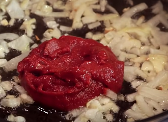 на сковороду к луку добавляем одну столовую ложку томатной пасты